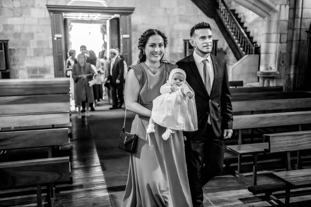 Papás entrando en la iglesia con bebé para su bautizo.